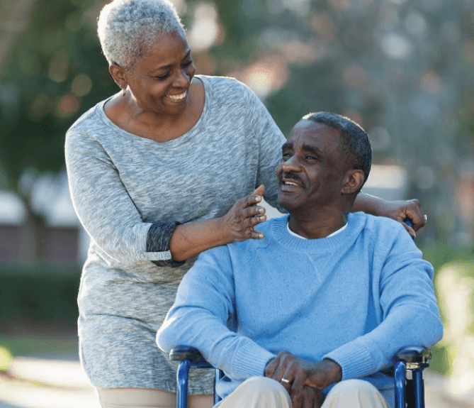 woman pushing senior man in his wheelchair