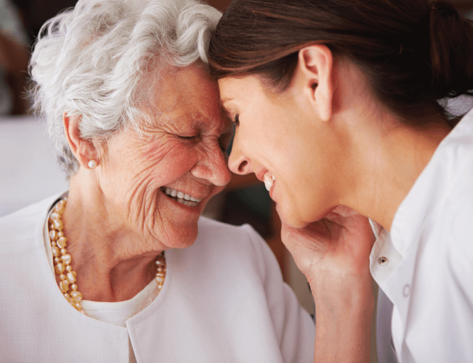 Senior woman and young woman touching foreheads