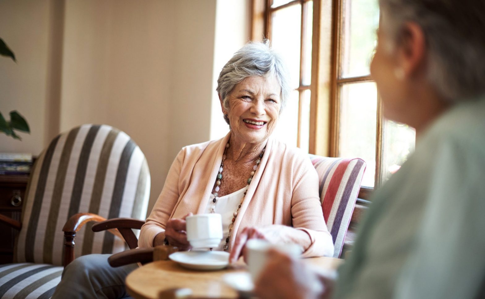 woman smiling while enjoying a drink