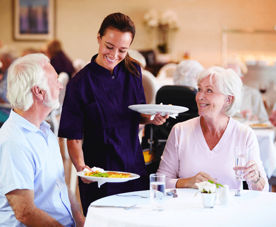 seniors enjoying dinner being served to them